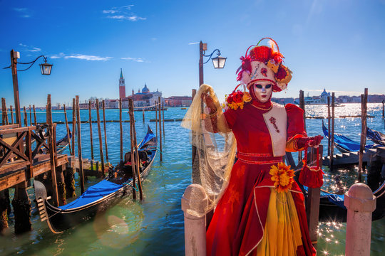Carnival masks against gondolas in Venice, Italy