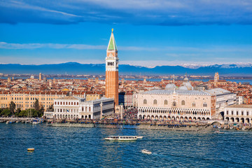 Fototapeta na wymiar Piazza San Marco with Bell Tower and the Doge Palace against Italian Alps in Venice, Italy