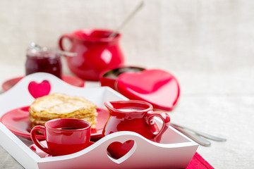 Breakfast. Pancakes and coffee with milk on a tray for Valentine