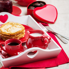 Breakfast. Pancakes and coffee with milk on a tray for Valentine