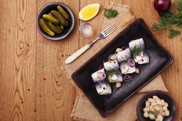 Rolled herring in vinegar, served with onions and pickles.