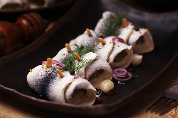 Rolled herring in vinegar, served with onions and pickles.