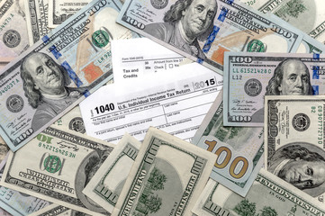 Tax form 1040 with US dollar bills