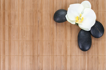 Fototapeta na wymiar Orchid with zen stones on bamboo background