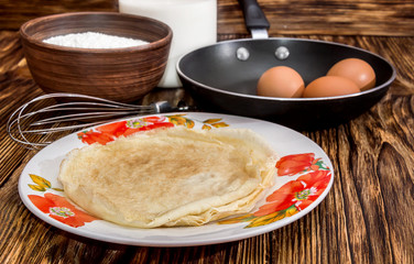 Pancakes and ingredients for baking them - milk, flour, eggs