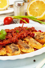 Pieces of fried fish with vegetable marinade.