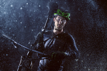 Mountainbiker carries his bike through the rain