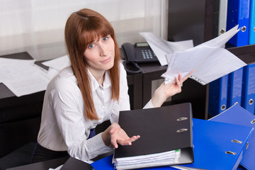 Overworked businesswoman with folders.