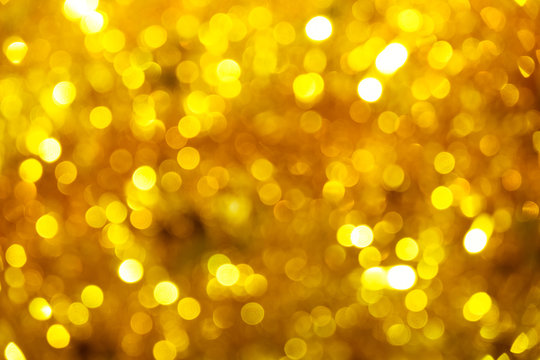 Gold glitter sparkle defocused rays lights bokeh abstract chistmas background.