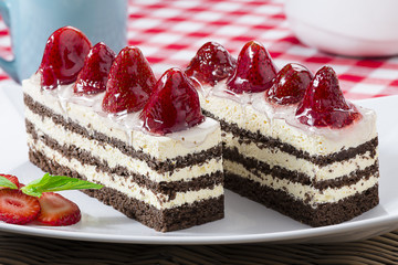 Rectangle piece of cake with strawberries on white plate.