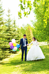 Bride and Groom at wedding Day walking Outdoors on spring nature. Bridal couple, Happy Newlywed woman and man embracing in green park. Loving wedding couple outdoor