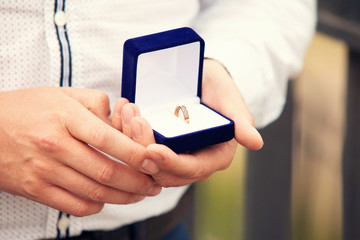 wedding rings in hands at the groom