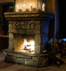 Fireplace room. Chimney, candles and woodpile. Classic interior.