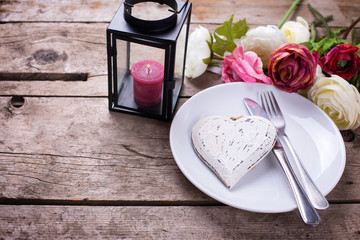 Decorative white  heart, knife and fork on white plate on vintag