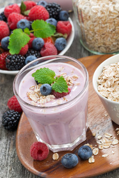 berry smoothie with oatmeal in a glass on wooden table, vertical