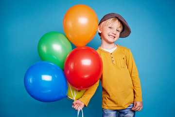 Fototapeta na wymiar Cute boy with colorful balloons
