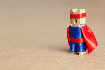 Clothespin superhero. Fun character dressed in blue suit and red cape, copy space