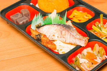 Food set of salmon grilled and other in a box.