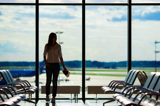 Airline passenger in an airport lounge waiting for flight aircraft