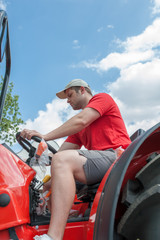 Young repairman ( farmer )  repairs tractor