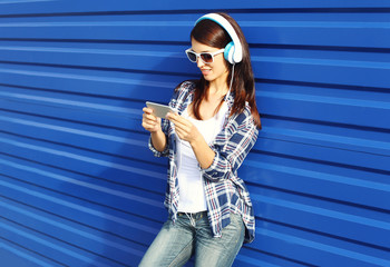 Pretty woman listens to music in headphones and using smartphone
