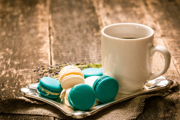 fresh macaroons and tea cup on wooden table .Vintage filter