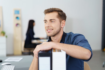 motivierter mitarbeiter im büro stützt sich auf aktenordner