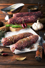 Raw minced meat on skewers with rosemary, garlic and spices