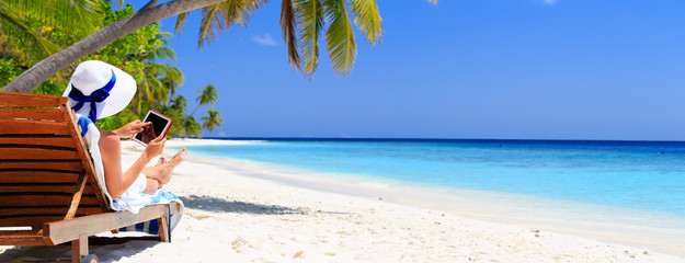 woman with touch pad on tropical beach