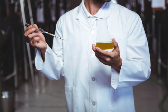 Brewer examining beer