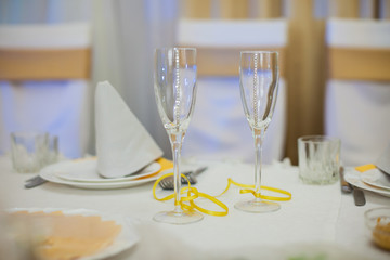 Two elegant decorated champagne glasses at wedding reception clo