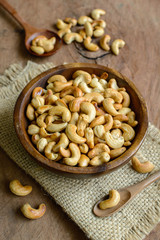 Fried cashew nuts with wooden spoon on sackcloth