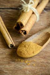 Cinnamon sticks and powder on wooden table
