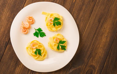 pasta decorated shrimp with parsley on a wooden background