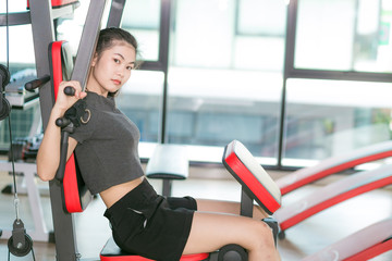 Attractive fitness asian woman training on gym equipment