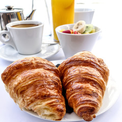 Breakfast with coffee and croissants on table