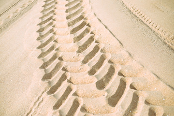 Wheel tracks on dry sand background