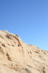 Fototapeta na wymiar Desert, sandy ground over background of blue sky