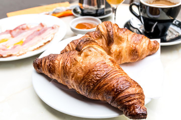 Breakfast with coffee and croissants on table
