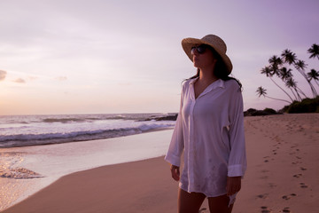 woman walking on the beach at sunset