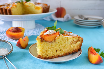 Delicate cake with peaches, dusted with icing sugar