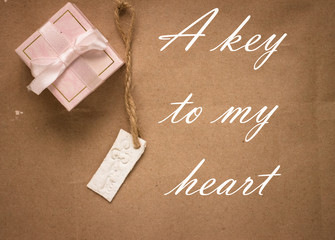 white key and pink gift box with ribbon closeup, a key to my hea