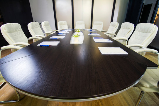 Top view of oval conference table with leather chairs