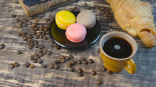 Black coffee and multicolored macarone on vintage background