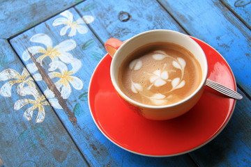 Red cup of coffee with heart and flower painted on foam