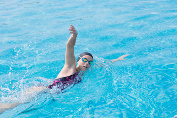 Woman in goggles swimming front crawl style