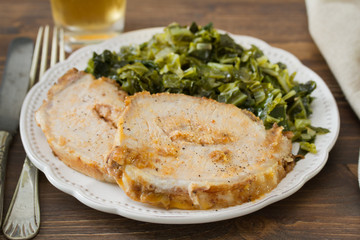 pork with cabbage on white plate on brown wooden background