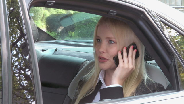 Business woman receives call in limousine 
