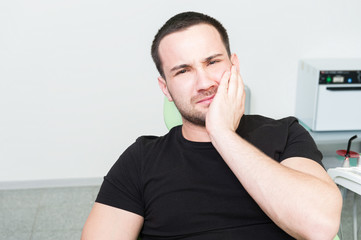 Sad dentist patient suffering toothache