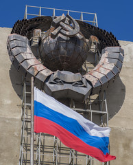 Российский флаг на фоне герба СССР, фокус на гербе